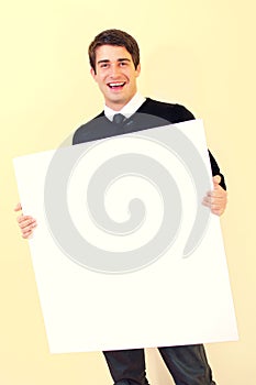 Happy young man holding blank white card