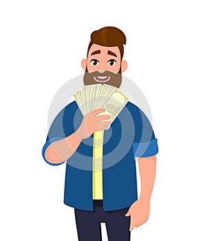 Happy young man holding cash/money/banknotes. Financial money concept. Human emotion and body language concept illustration.