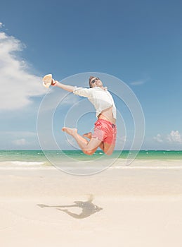 Happy young man jumping on the beach