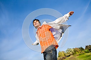 Happy young man - jumping end flies in blue sky.