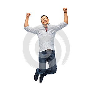 Happy young man jumping over white background