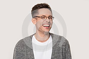 Happy young man laughing at funny joke squinting his eyes
