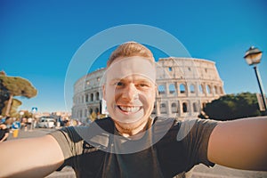 Happy young man making selfie in front of Colosseum in Rome, Italy. Concept travel trip