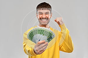 Happy young man with money celebrating success