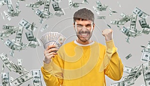 Happy young man with money celebrating success