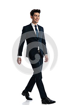 happy young man in navy blue suit smiling and walking