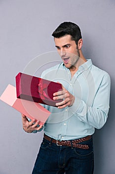 Happy young man opening gift box