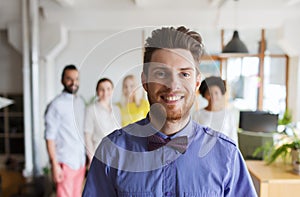 Happy young man over creative team in office