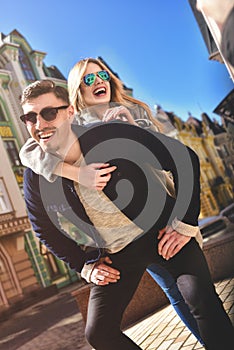 Happy young man piggybacking his girlfriend