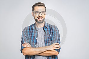 Happy young man. Portrait of handsome young man in casual shirt keeping arms crossed and smiling while standing against grey