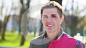 Happy young man posing in sunny park