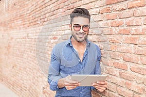 Happy young man reading on a tablet computer