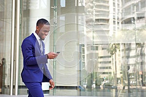 Happy young man reading text message on his mobile phone