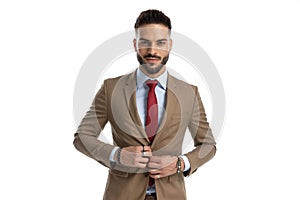 Happy young man with red tie adjusting and unbuttoning jacket