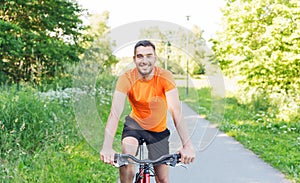 Happy young man riding bicycle outdoors