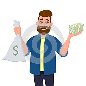 Happy young man is showing or holding money bag, cash bag and bunch of money, cash, currency, dollar bills, banknotes in hand.