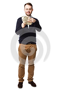 Happy young man showing off a handful of money