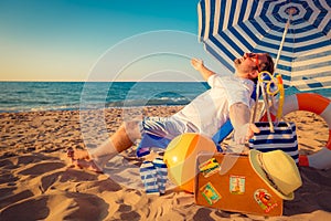 Happy young man sitting on the beach