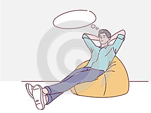 Happy young man sitting in orange beanbag chair, he is relaxing