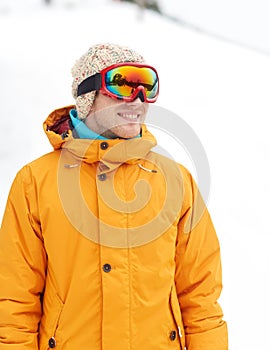 Happy young man in ski goggles outdoors