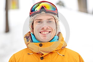 Happy young man in ski goggles outdoors