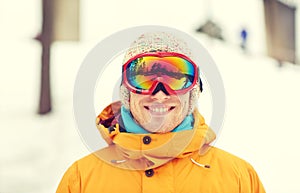 Happy young man in ski goggles outdoors