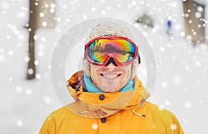 Happy young man in ski goggles outdoors