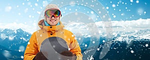 Happy young man in ski goggles over mountains