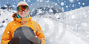 Happy young man in ski goggles over mountains