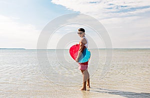 Happy young man with skimboard on summer beach