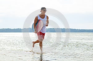 Happy young man with skimboard on summer beach