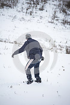 Happy young man with snowboard enjoying sunny weather in snowy mountains. Winter sport and recreation, leasure outdoor activities