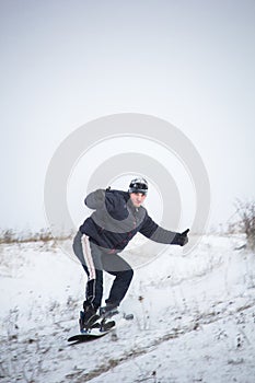 Happy young man with snowboard enjoying sunny weather in snowy mountains. Winter sport and recreation, leasure outdoor activities