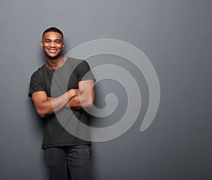 Happy young man standing with arms crossed