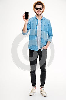 Happy young man standing and holding blank screen cell phone