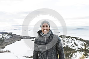 Happy young man standing outdoors on winter mountain resort