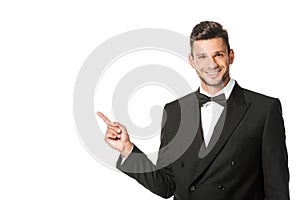 happy young man in suit pointing at blank space