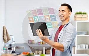 Happy young man with tablet computer in kitchen