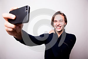 Happy young man taking self portrait photography through smart phone