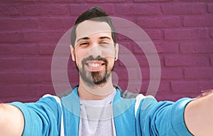 Happy young man taking a selfie.