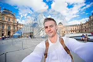 Happy young man taking a selfie photo in Paris