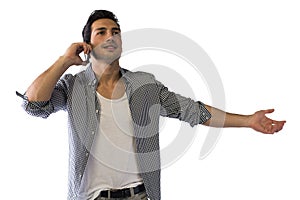 Happy young man talking on cell phone with arms open