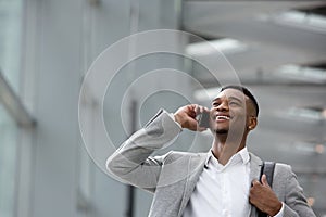 Happy young man talking on mobile phone inside building