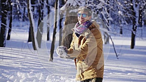 Happy young man throwing snow up in front of camera in slow motion. Winter mood. Winter, sport, holidays, xmas