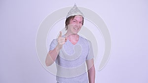 Happy young man with tinfoil hat pointing at camera