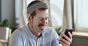 Happy young man user having mobile conversation on speakerphone