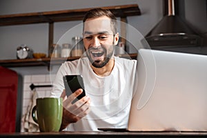 Happy young man using laptop computer