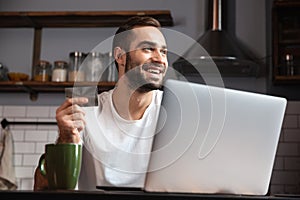 Happy young man using laptop computer