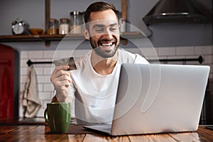 Happy young man using laptop computer