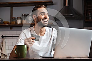 Happy young man using laptop computer